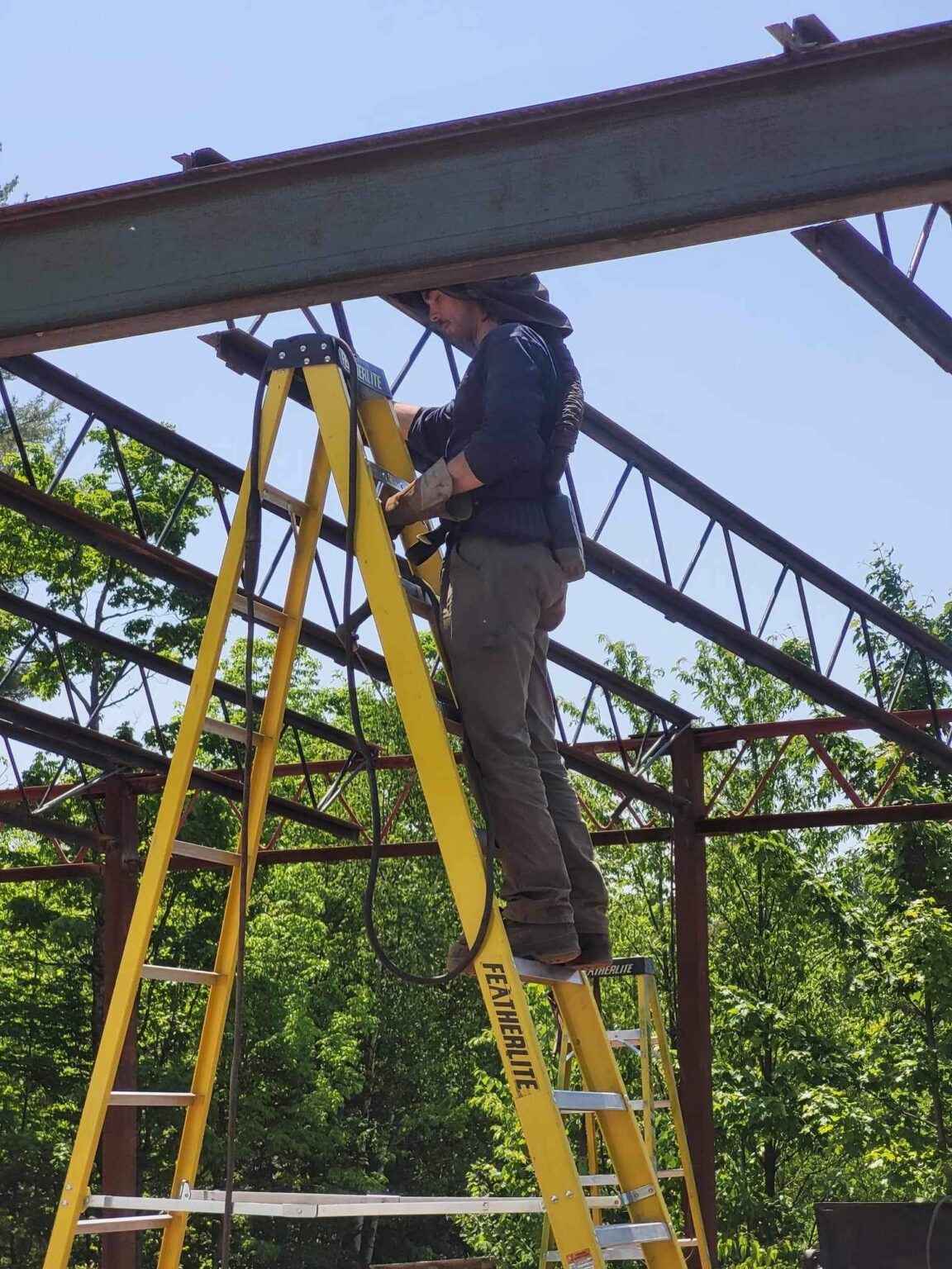 Employés de l'entreprise soudures mobiles LPM dans une échelle entrain de souder une structure de métal